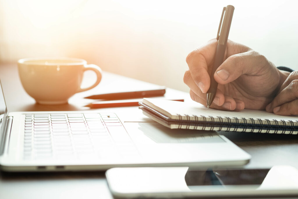 man hand using writing pen memo on notebook paper or letter, diary on table desk office. Workplace for student, writer with copy space. business working and learning education concept.